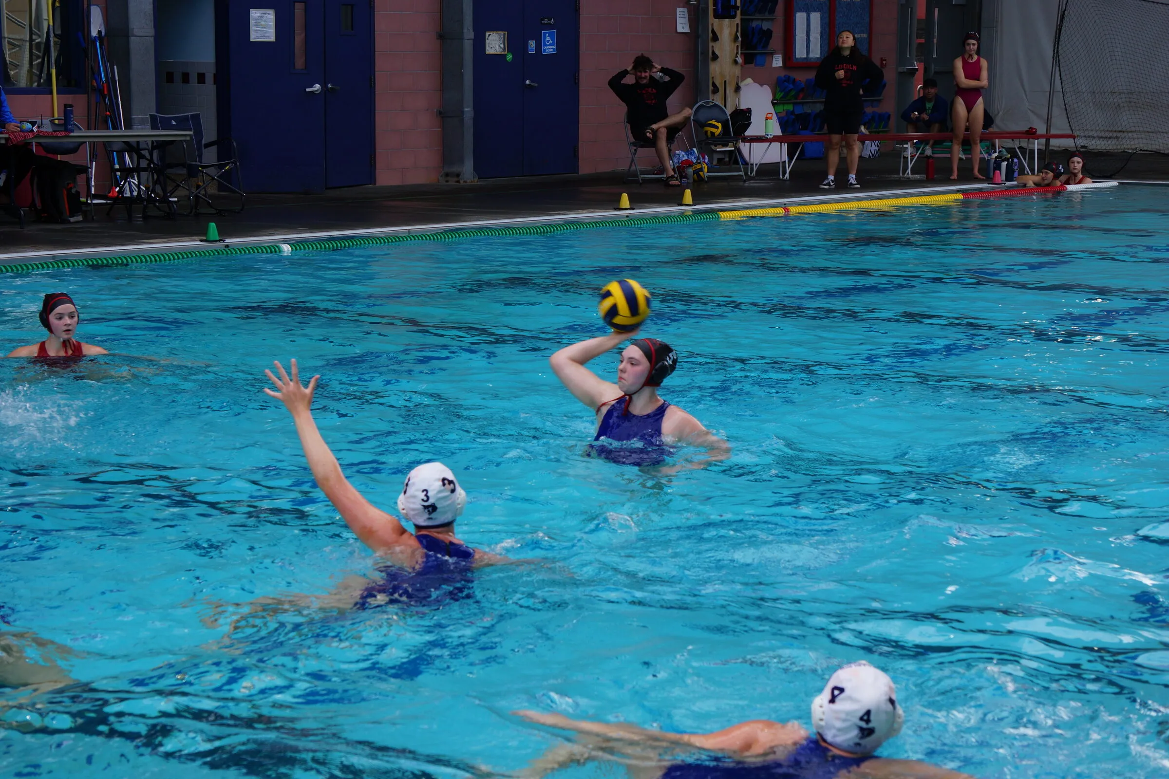 Players spread out as the ball comes across the pool