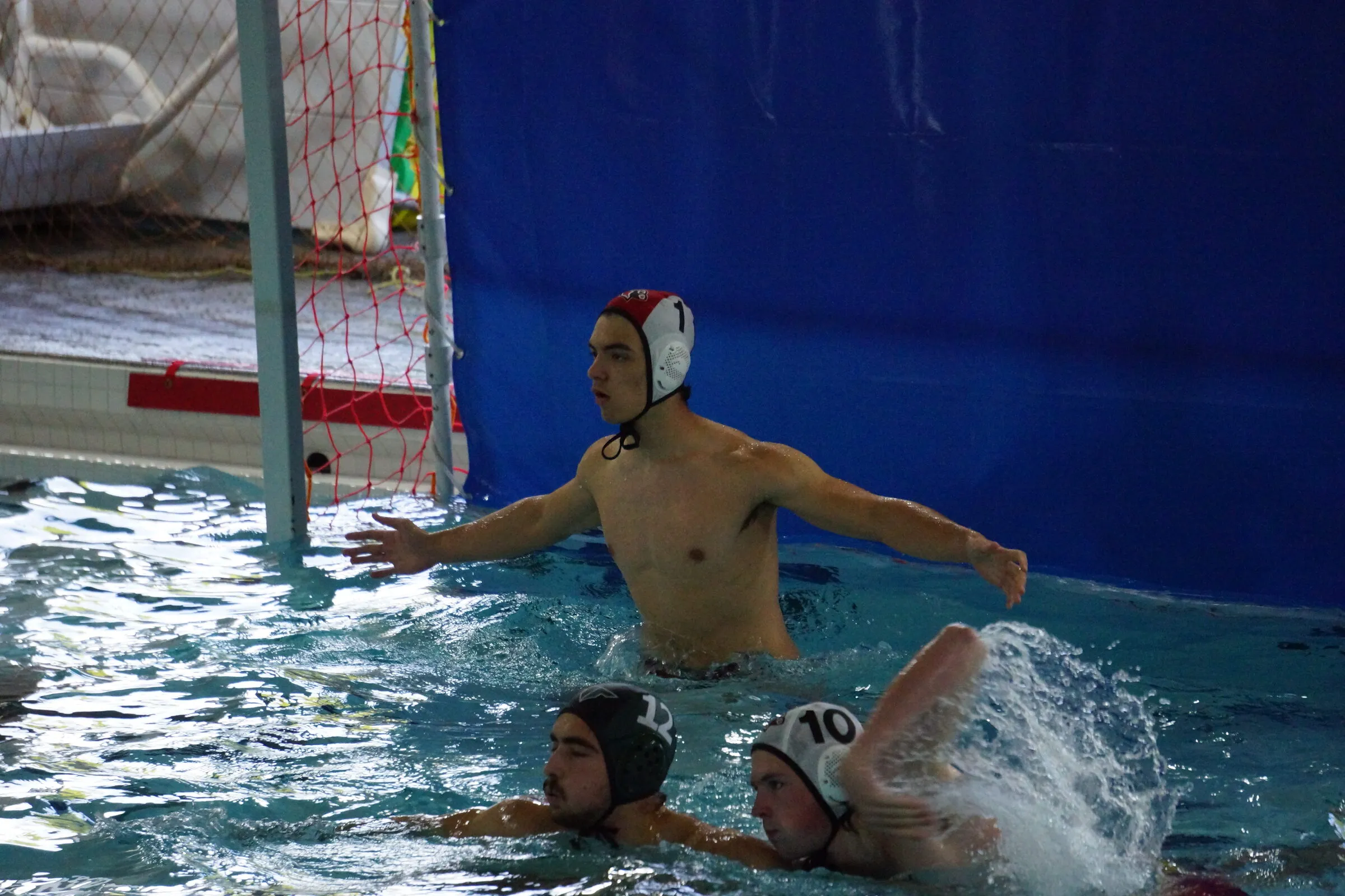 The goalie spreads wide across the cage